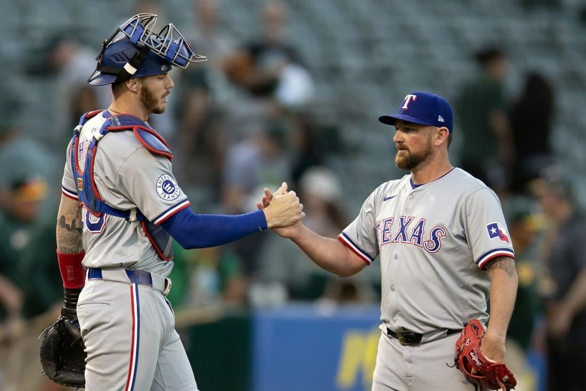 May 8, 2024; Oakland, California, USA; Texas Rangers catcher Jonah Heim (28) and pitcher Kirby Yates (39) celebrate their victory over the Oakland Athletics at Oakland-Alameda County Coliseum.