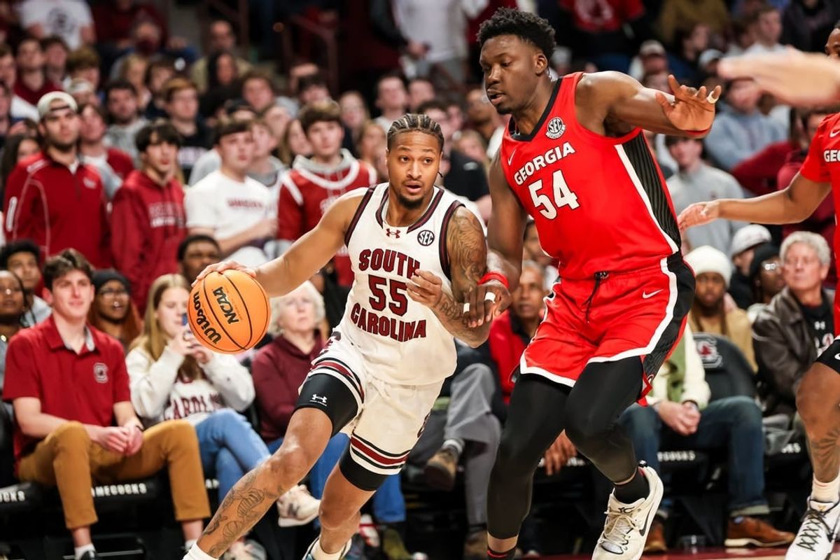 Jan 16, 2024; Columbia, South Carolina, USA; South Carolina Gamecocks guard Ta'Lon Cooper (55) drives around Georgia Bulldogs center Russel Tchewa (54) in the first half at Colonial Life Arena.