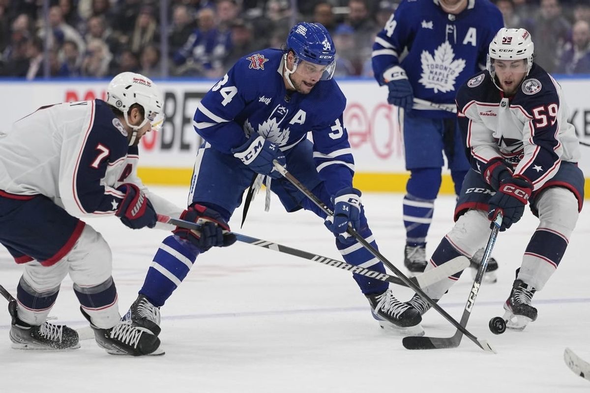 Dec 14, 2023; Toronto, Ontario, CAN; Toronto Maple Leafs forward Auston Matthews (34) battles for th epuck with Columbus Blue Jackets forward Sean Kuraly (7) and Columbus Blue Jackets forward Yegor Chinakhov (59) during the third period at Scotiabank Arena.