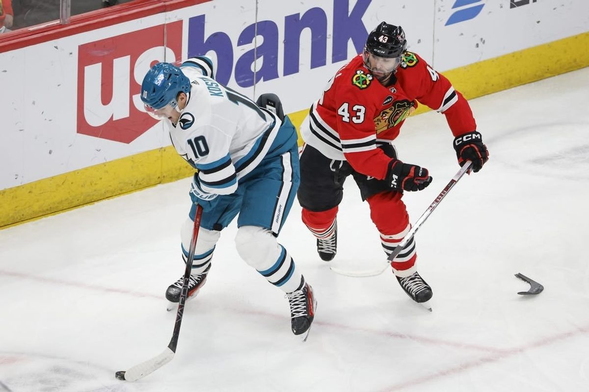 Mar 17, 2024; Chicago, Illinois, USA; San Jose Sharks center Klim Kostin (10) keeps the puck away from Chicago Blackhawks center Colin Blackwell (43) during the first period at United Center.
