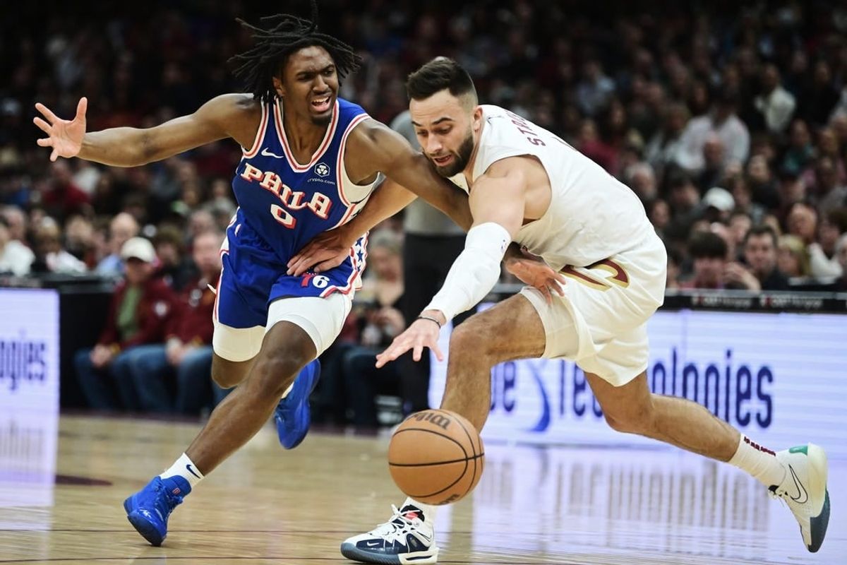 Mar 29, 2024; Cleveland, Ohio, USA; Philadelphia 76ers guard Tyrese Maxey (0) and Cleveland Cavaliers guard Max Strus (1) go for a loose ball during the first half at Rocket Mortgage FieldHouse.