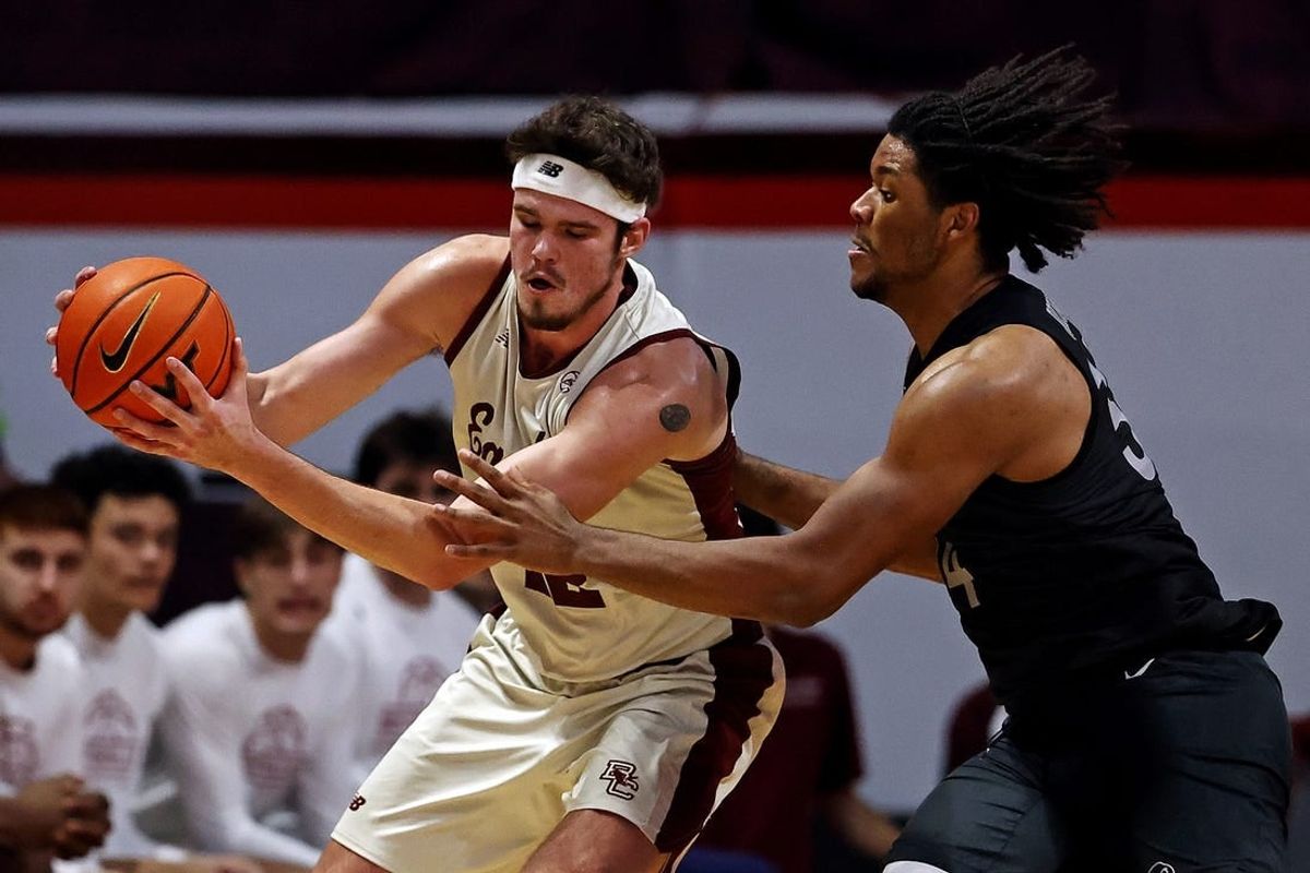 Jan 23, 2024; Blacksburg, Virginia, USA; Boston College Eagles forward Quinten Post (12) handles the ball against Virginia Tech Hokies forward Mylyjael Poteat (34) during the second half at Cassell Coliseum.