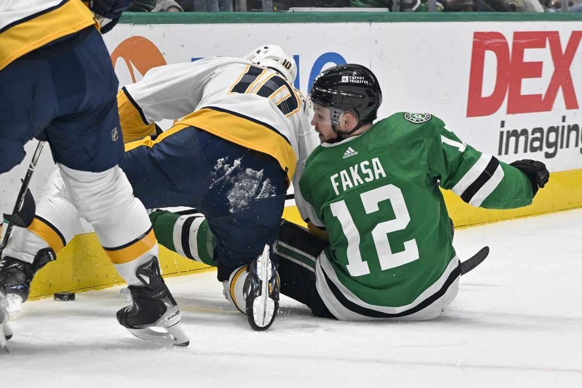 Jan 6, 2024; Dallas, Texas, USA; Nashville Predators center Colton Sissons (10) and Dallas Stars center Radek Faksa (12) battle for control of the puck along the boards during the second period at the American Airlines Center.