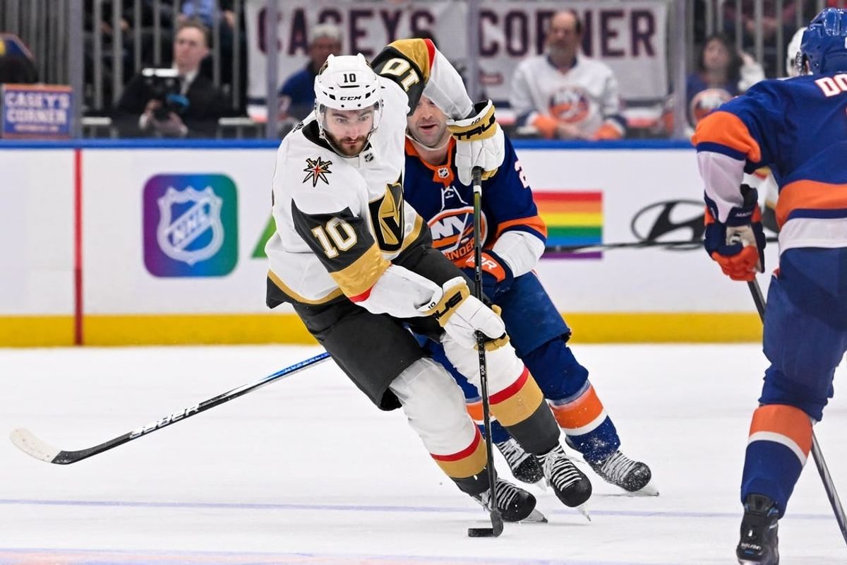 Jan 23, 2024; Elmont, New York, USA;  Vegas Golden Knights center Nicolas Roy (10) skates with the puck defended by New York Islanders defenseman Noah Dobson (8) during the third period at UBS Arena.