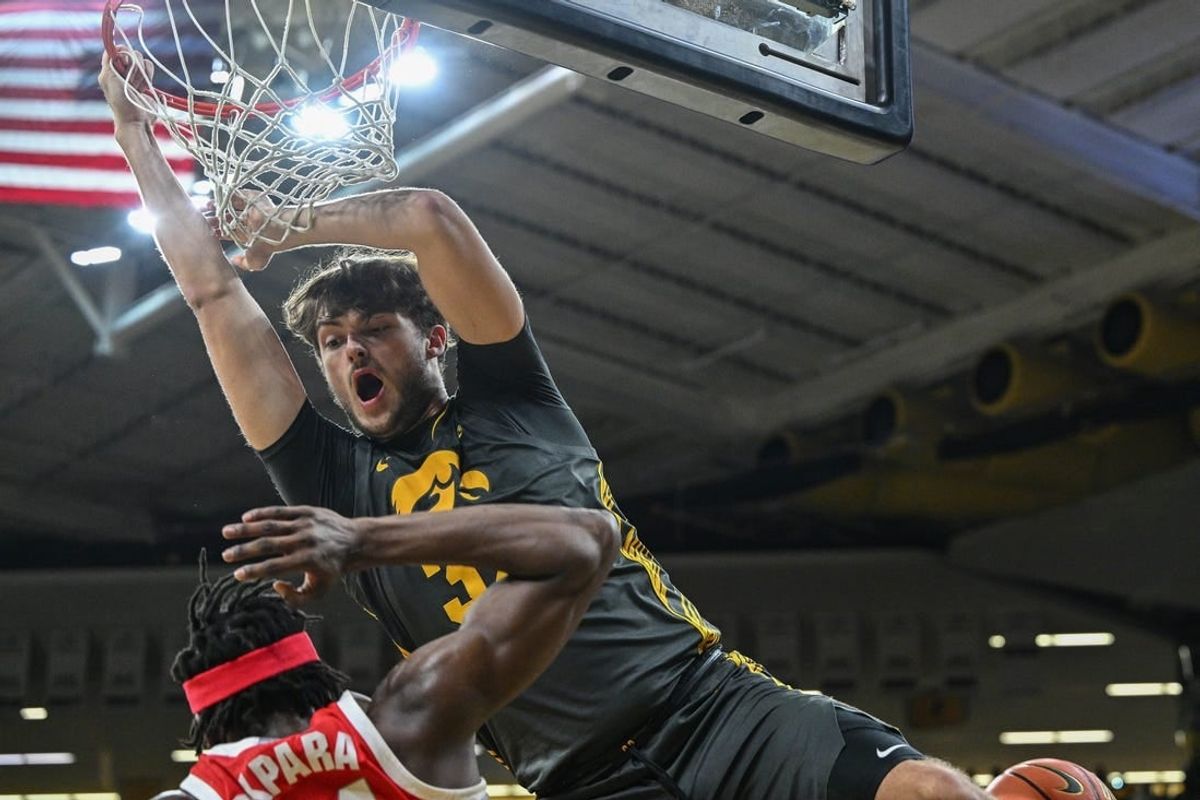 Feb 2, 2024; Iowa City, Iowa, USA; Iowa Hawkeyes forward Owen Freeman (32) completes a slam dunk over Ohio State Buckeyes center Felix Okpara (34) during the second half at Carver-Hawkeye Arena.