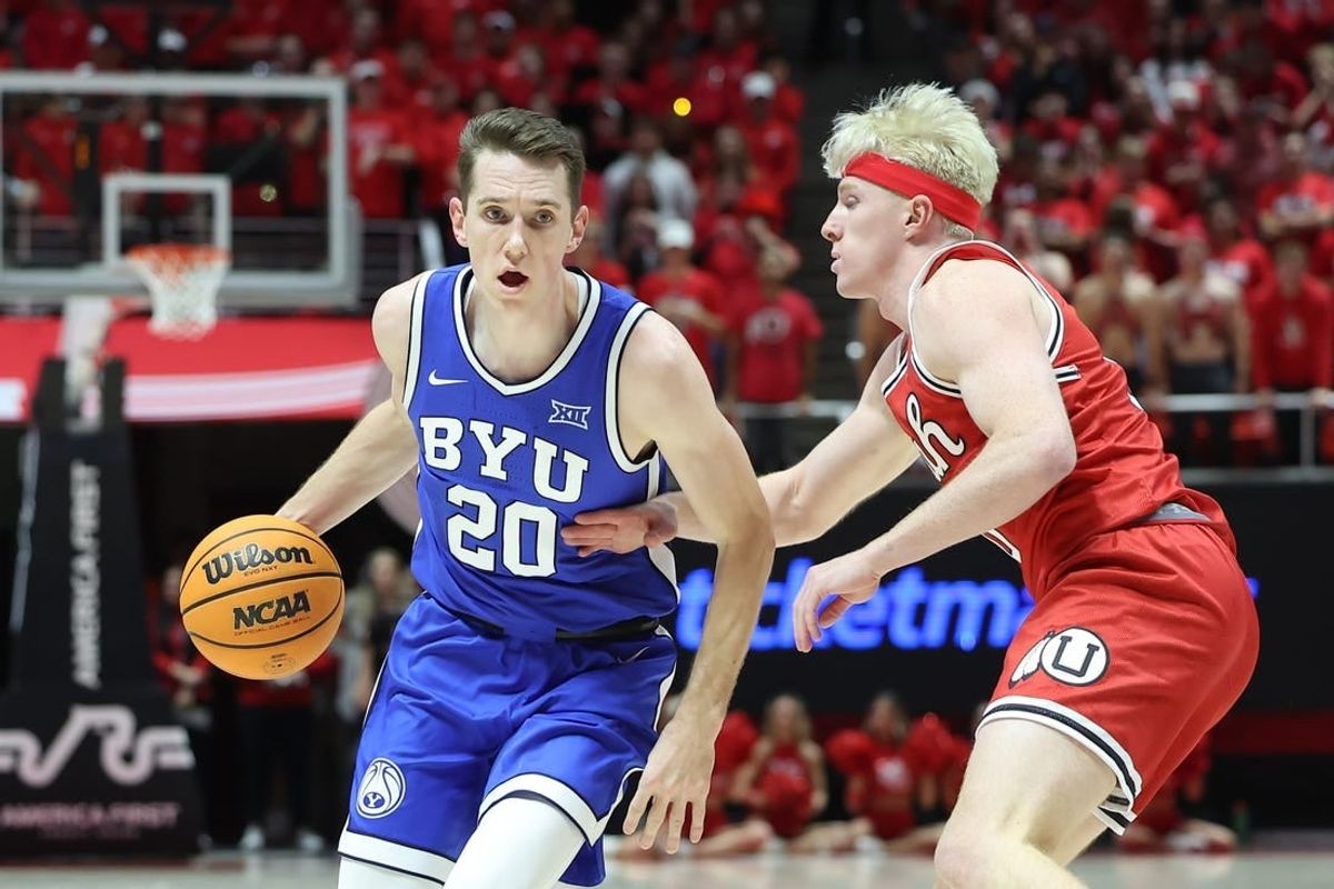 Dec 9, 2023; Salt Lake City, Utah, USA; Brigham Young Cougars guard Spencer Johnson (20) drives against Utah Utes guard Hunter Erickson (0) during the first half at Jon M. Huntsman Center.