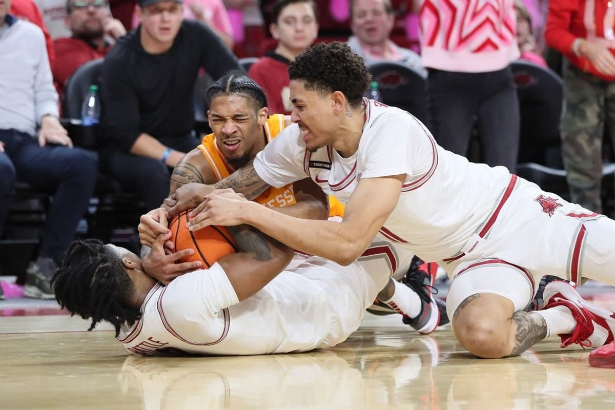 Feb 14, 2024; Fayetteville, Arkansas, USA; Tennessee Volunteers guard Zakai Zeigler (5) fights for a loose ball with Arkansas Razorbacks guard Khalif Battle (0) and forward Jalen Graham (11) during the first half at Bud Walton Arena.