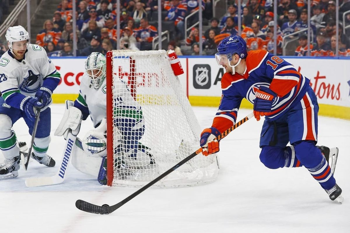 Apr 13, 2024; Edmonton, Alberta, CAN; Edmonton Oilers forward Zach Hyman (18) looks to make a pass from behind Vancouver Canucks goaltender Casey DeSmith (29) during the third period at Rogers Place.