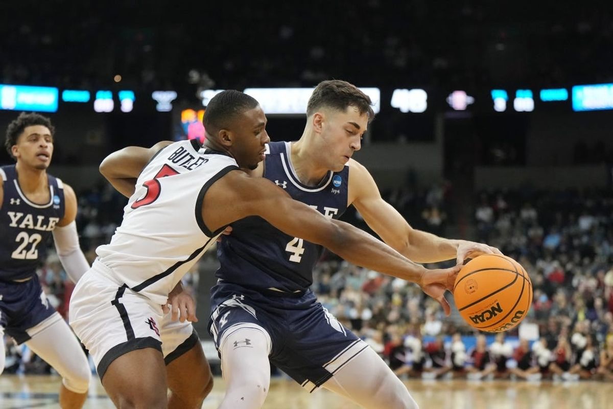 Mar 24, 2024; Spokane, WA, USA; Yale Bulldogs guard John Poulakidas (4) battles San Diego State Aztecs guard Lamont Butler (5) for the ball in the second half at Spokane Veterans Memorial Arena.
