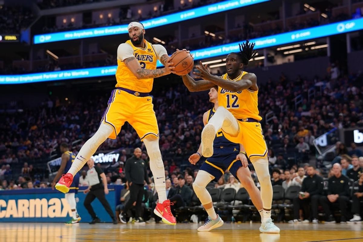 Feb 22, 2024; San Francisco, California, USA; Los Angeles Lakers forward Anthony Davis (3) holds onto a rebound next to forward Taurean Prince (12) against the Golden State Warriors in the third quarter at the Chase Center.