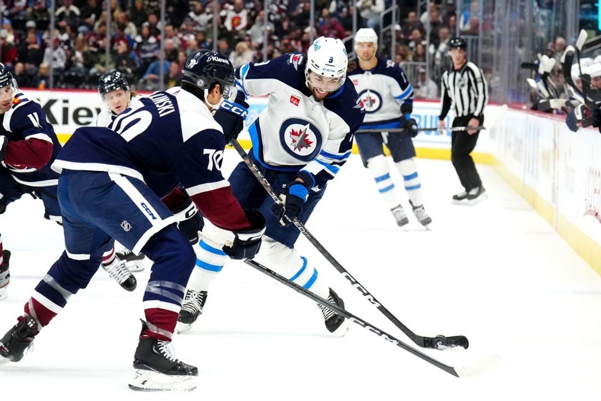 Dec 7, 2023; Denver, Colorado, USA; Winnipeg Jets left wing Alex Iafallo (9) shoots the puck towards Colorado Avalanche defenseman Sam Malinski (70) in the first period at Ball Arena.