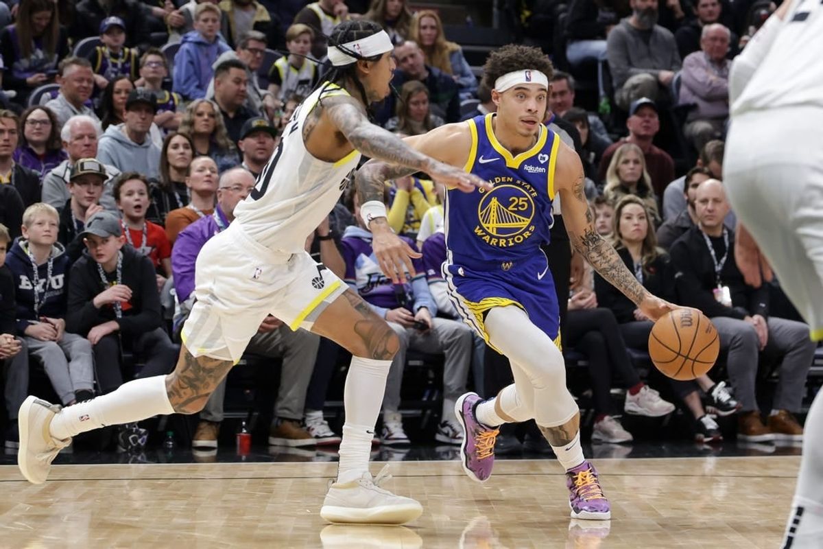 Feb 15, 2024; Salt Lake City, Utah, USA; Golden State Warriors guard Lester Quinones (25) dribbles away from Utah Jazz guard Jordan Clarkson (00) during the second half at Delta Center.