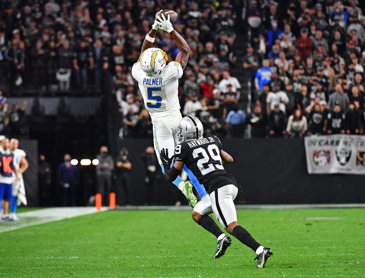 Jan 9, 2022; Paradise, Nevada, USA;Los Angeles Chargers wide receiver Josh Palmer (5) attempts catch a pass as Las Vegas Raiders cornerback Casey Hayward (29) defends during the fourth quarter at Allegiant Stadium.