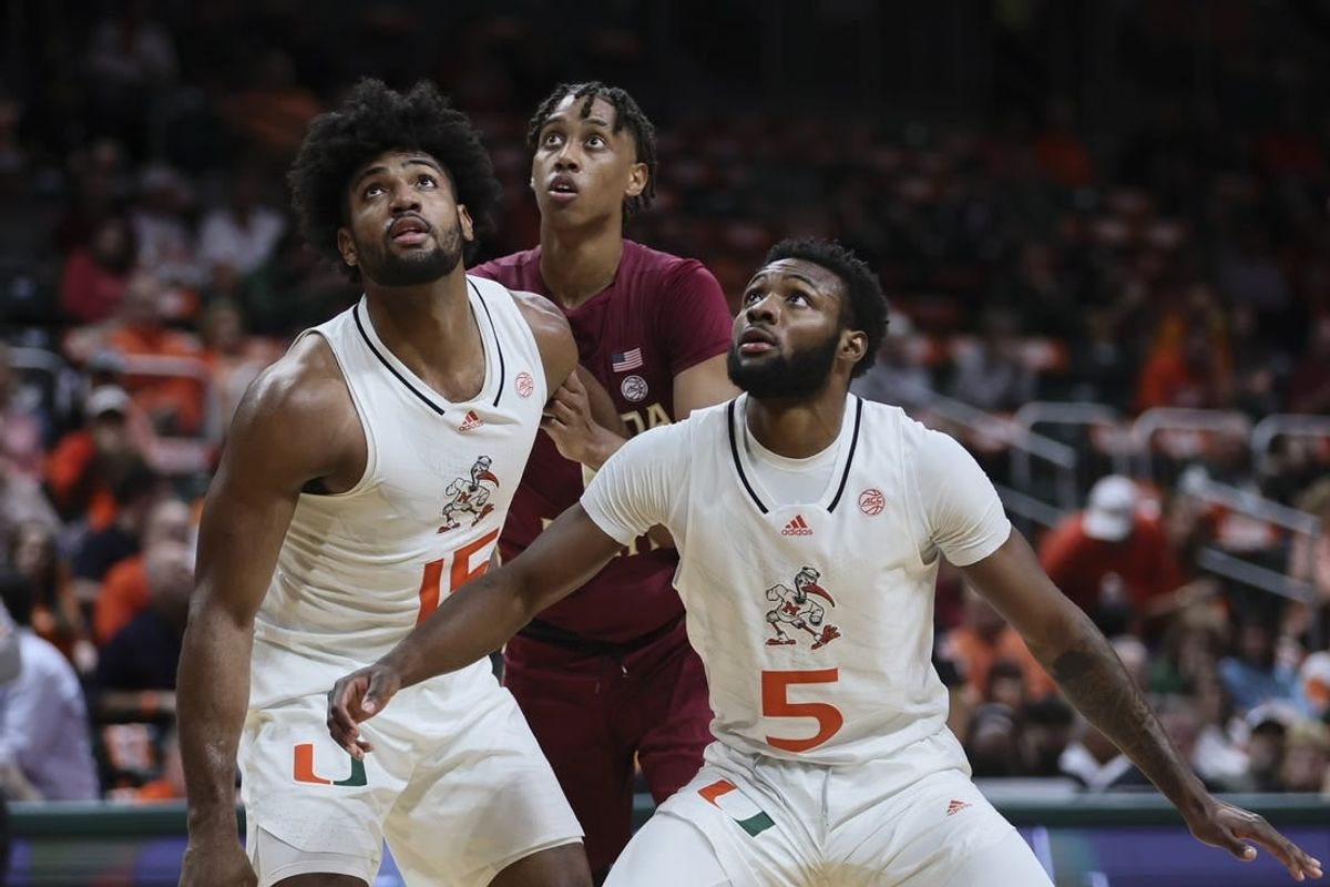Jan 17, 2024; Coral Gables, Florida, USA; Miami Hurricanes guard Wooga Poplar (5) and forward Norchad Omier (15) guard Florida State Seminoles forward Baba Miller (11) during the first half at Watsco Center.