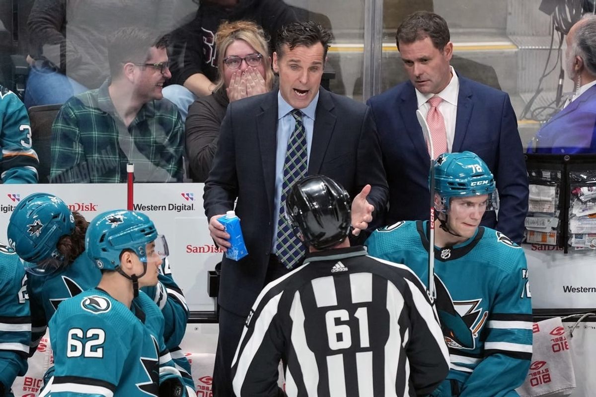 Mar 11, 2023; San Jose, California, USA; San Jose Sharks head coach David Quinn (center) talks to linesman James Tobias (61) during the third period against the Minnesota Wild at SAP Center at San Jose.