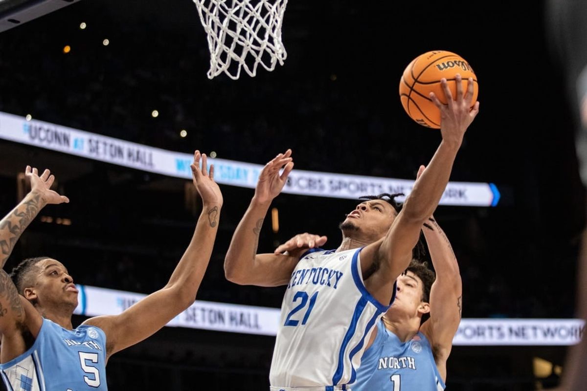 Dec 16, 2023; Atlanta, Georgia, USA; Kentucky Wildcats guard D.J. Wagner (21) attempts layup shot against North Carolina Tar Heels forward Armando Bacot (5) and North Carolina Tar Heels forward Zayden High (1) during the first half at State Farm Arena.