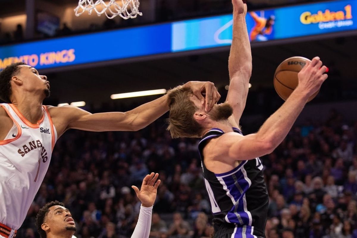 Feb 22, 2024; Sacramento, California, USA; Sacramento Kings forward Domantas Sabonis (10) is fouled by San Antonio Spurs center Victor Wembanyama (1) during the second quarter at Golden 1 Center.
