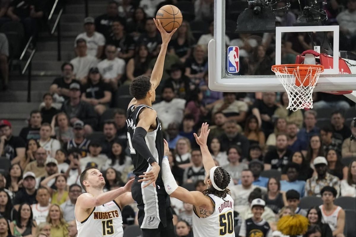 Apr 12, 2024; San Antonio, Texas, USA; San Antonio Spurs forward Victor Wembanyama (1) shoots over Denver Nuggets center Nikola Jokic (15) and forward Aaron Gordon (50) during the second half at Frost Bank Center.
