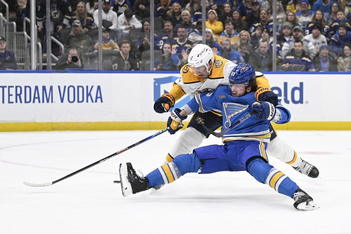 Feb 17, 2024; St. Louis, Missouri, USA; St. Louis Blues left wing Jake Neighbours (63) is awarded a penalty shot after being taken down by Nashville Predators defenseman Luke Schenn (2) during the second period at Enterprise Center.