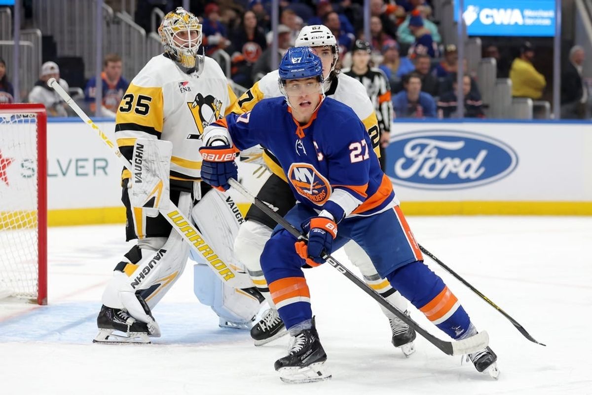 Dec 27, 2023; Elmont, New York, USA; New York Islanders left wing Anders Lee (27) skates against Pittsburgh Penguins goaltender Tristan Jarry (35) and defenseman Ryan Graves (27) during the second period at UBS Arena.