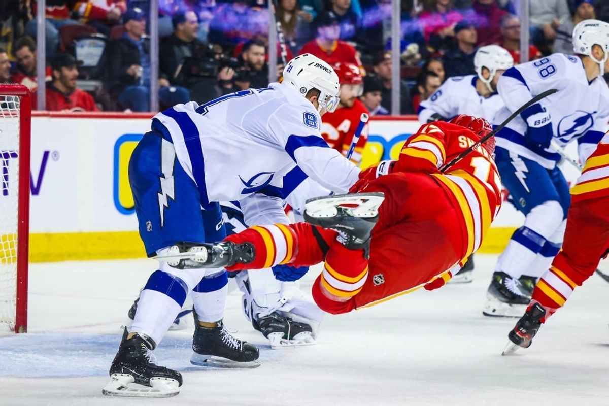 Dec 16, 2023; Calgary, Alberta, CAN; Tampa Bay Lightning defenseman Erik Cernak (81) and Calgary Flames center Yegor Sharangovich (17) battle for the puck during the second period at Scotiabank Saddledome.