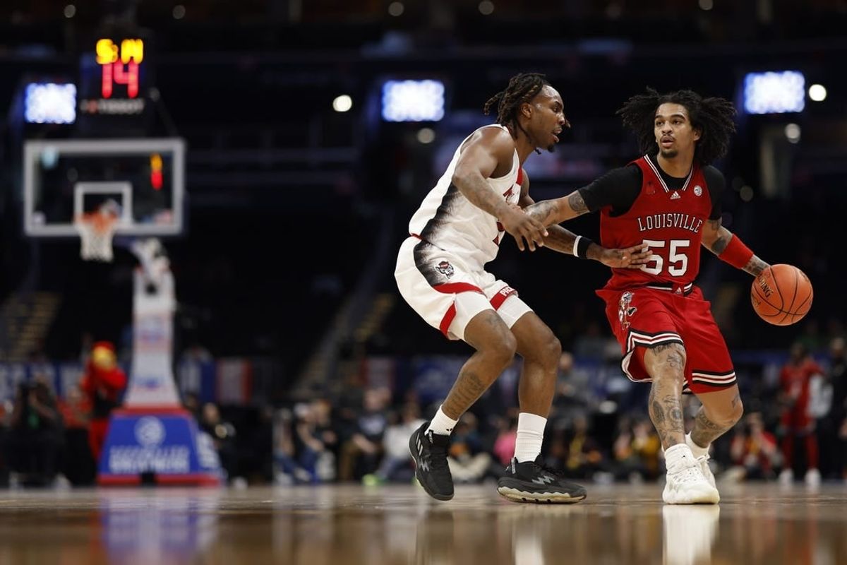 Mar 12, 2024; Washington, D.C., USA; Louisville Cardinals guard Skyy Clark (55) drives to the basket as North Carolina State Wolfpack guard Jayden Taylor (1) defends in the first half at Capital One Arena.