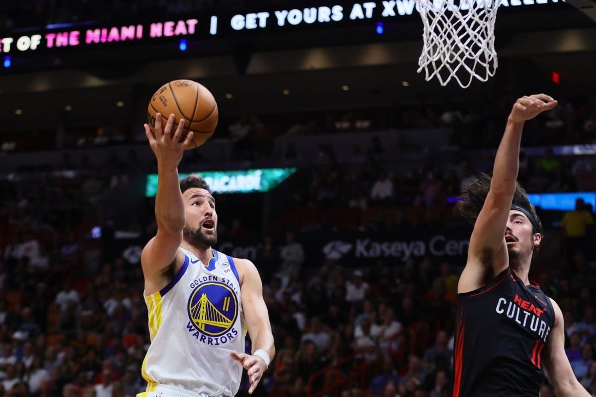 Mar 26, 2024; Miami, Florida, USA; Golden State Warriors guard Klay Thompson (11) drives to the basket against Miami Heat guard Jaime Jaquez Jr. (11) during the first quarter at Kaseya Center.