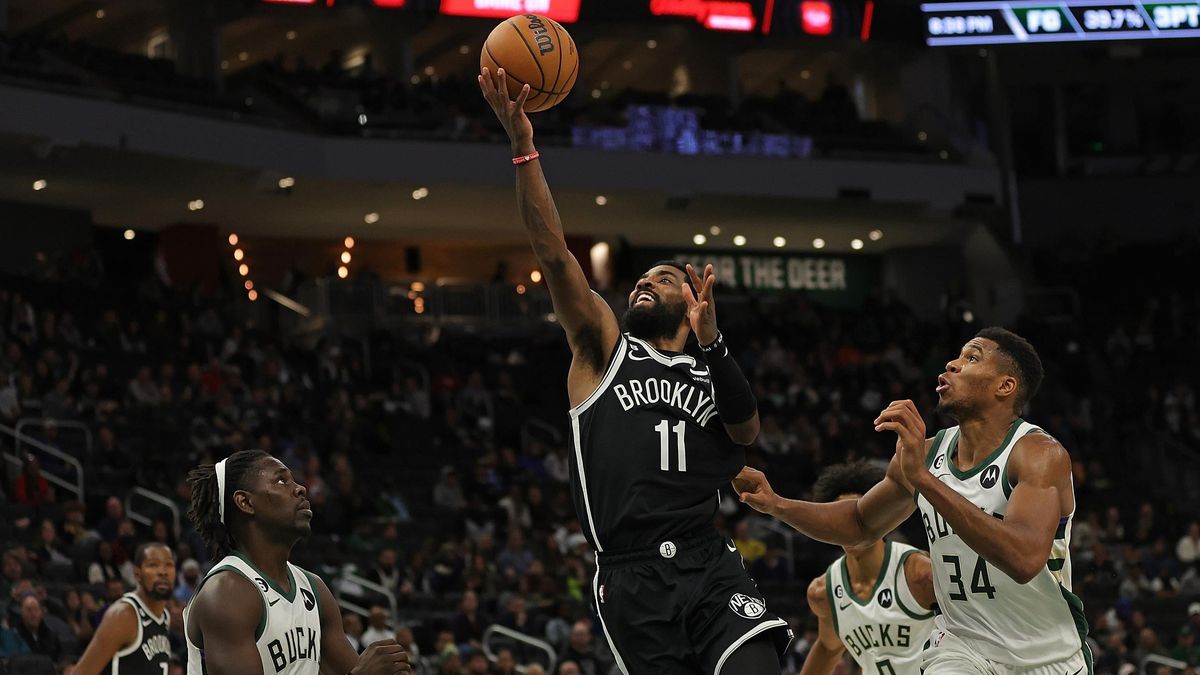 Kyrie Irving of the Brooklyn Nets is defended by Giannis Antetokounmpo of the Milwaukee Bucks during a preseason game at Fiserv Forum on October 12, 2022 in Milwaukee, Wisconsin.