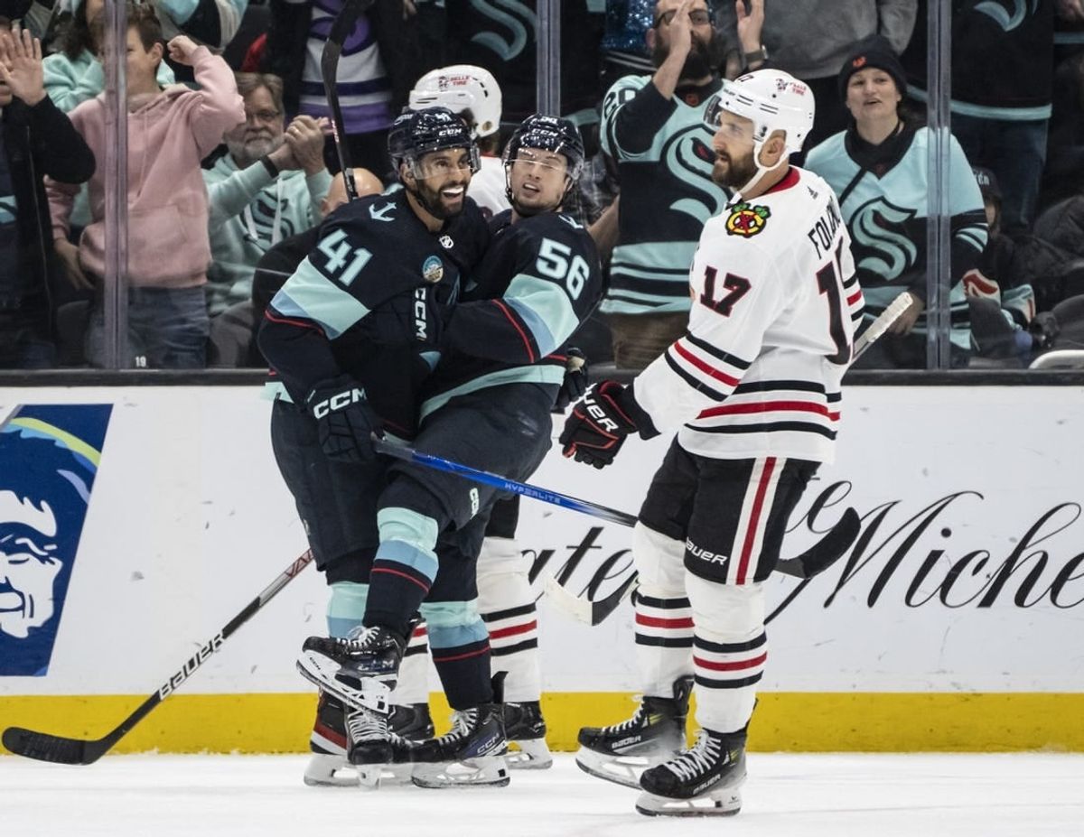 Dec 14, 2023; Seattle, Washington, USA; Seattle Kraken forward Kailer Yamamoto (56) celebrates with forward Pierre-Edouard Bellemare (41) in front of Chicago Blackhawks forward Nick Foligno (17) after scoring a goal during the first period at Climate Pledge Arena.