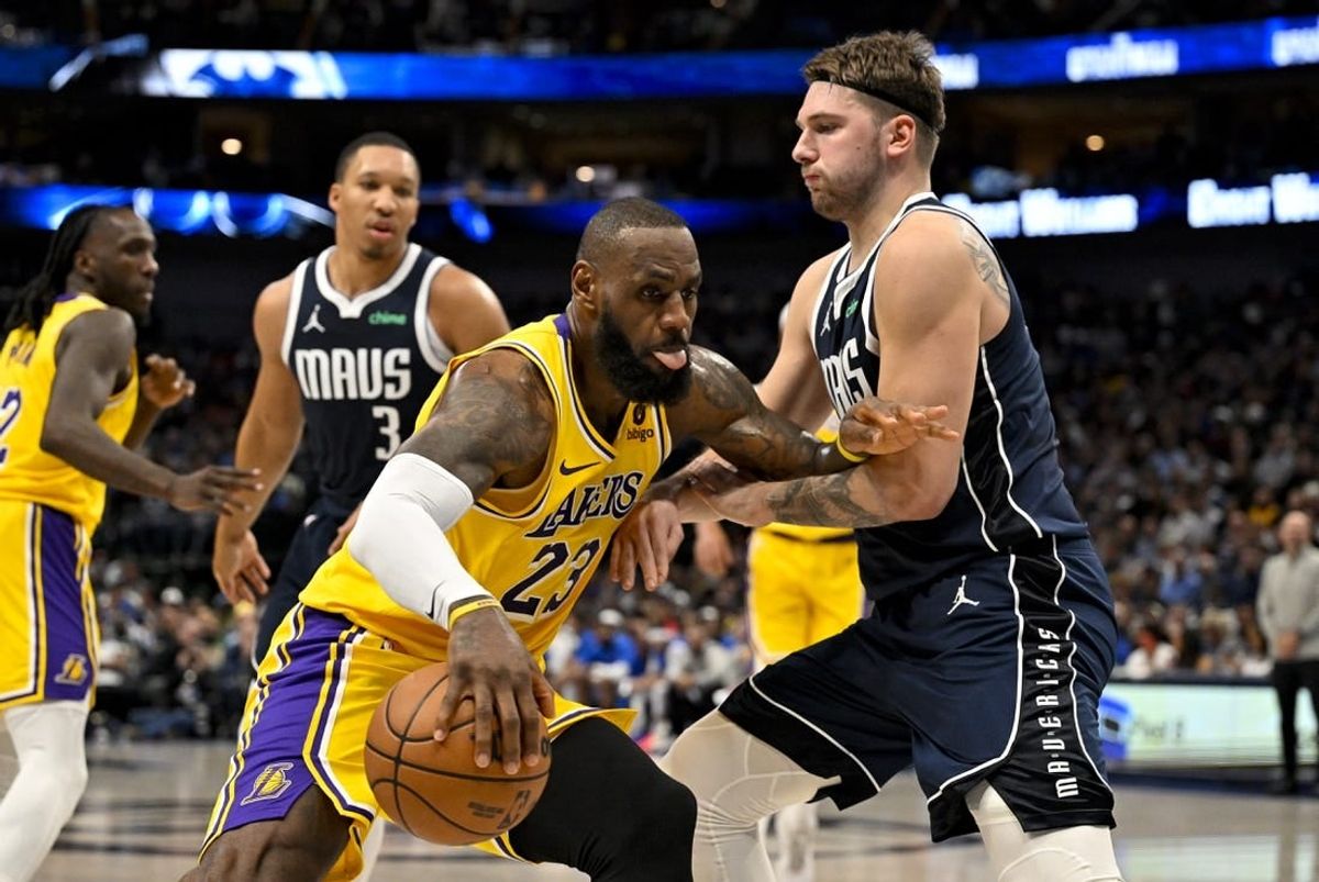 Dec 12, 2023; Dallas, Texas, USA; Los Angeles Lakers forward LeBron James (23) looks to move the ball past Dallas Mavericks guard Luka Doncic (77) during the second quarter at the American Airlines Center.