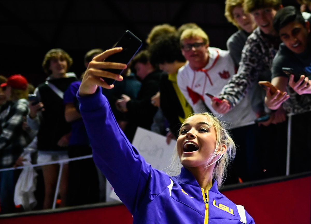 Olivia Dunne of LSU takes a selfie with fans after a PAC-12 meet against Utah