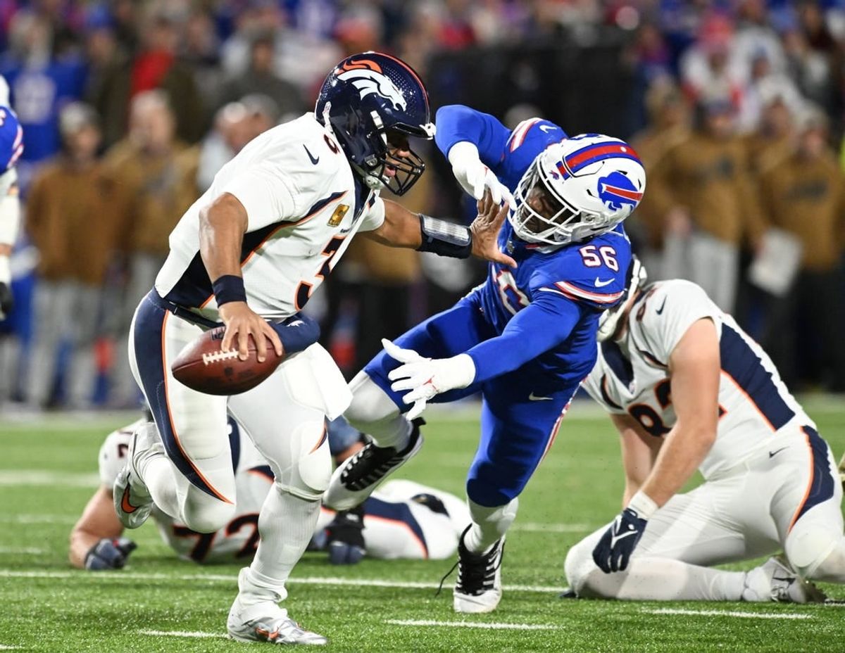 Nov 13, 2023; Orchard Park, New York, USA; Denver Broncos quarterback Russell Wilson (3) gives a stiff arm to Buffalo Bills defensive end Leonard Floyd (56) in the second quarter at Highmark Stadium.