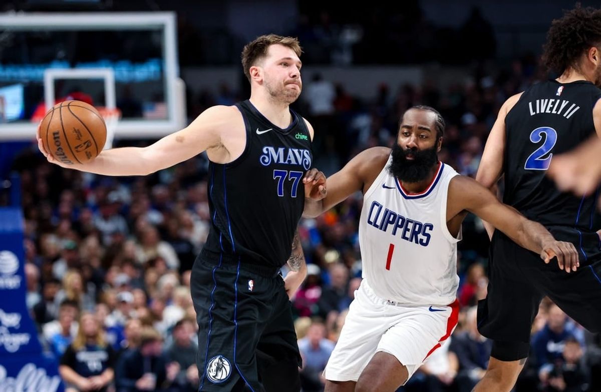 Nov 10, 2023; Dallas, Texas, USA;  Dallas Mavericks guard Luka Doncic (77) passes around LA Clippers guard James Harden (1) during the second quarter at American Airlines Center.