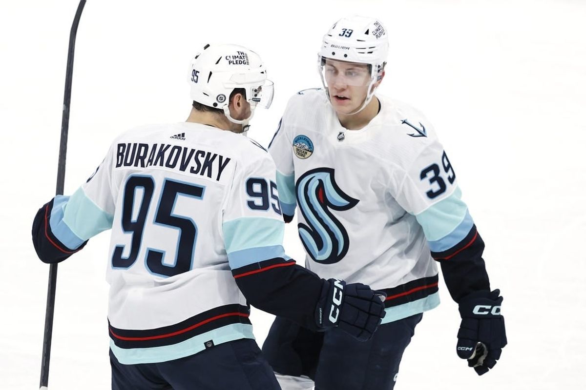 Mar 5, 2024; Winnipeg, Manitoba, CAN; Seattle Kraken left wing Andre Burakovsky (95) celebrates his third period goal with  Seattle Kraken defenseman Ryker Evans (39) against the Winnipeg Jets at Canada Life Centre.
