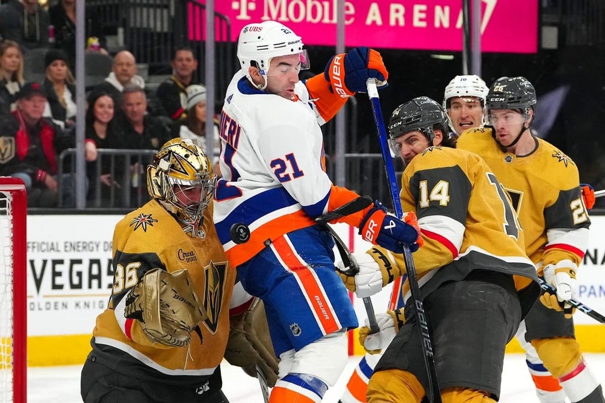 Jan 6, 2024; Las Vegas, Nevada, USA; A shot deflects off New York Islanders center Kyle Palmieri (21) between Vegas Golden Knights goaltender Logan Thompson (36) and Vegas Golden Knights defenseman Nicolas Hague (14) during the first period at T-Mobile Arena.