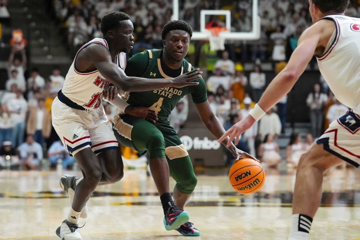 Jan 27, 2024; Laramie, Wyoming, USA; Colorado State Rams forward Isaiah Stevens (4) controls the ball against Wyoming Cowboys guard Akuel Kot (13) during the first half at Arena-Auditorium.