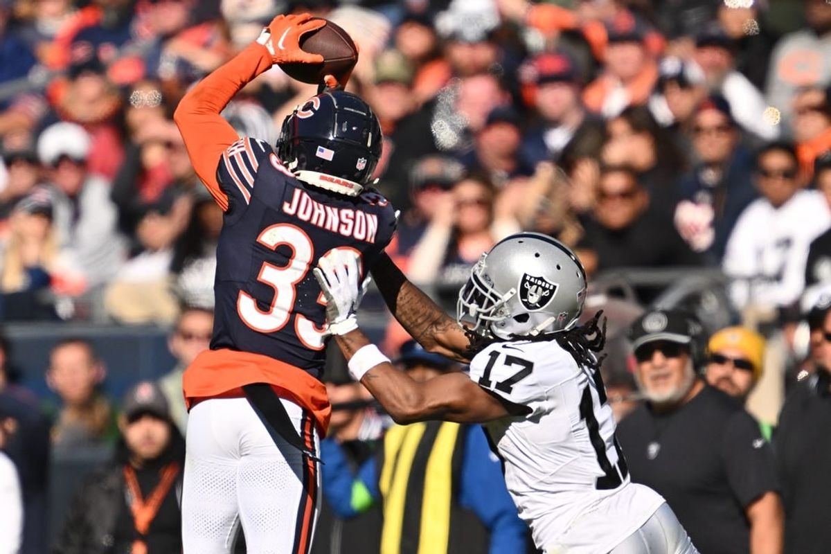 Oct 22, 2023; Chicago, Illinois, USA;  Chicago Bears defensive back Jaylon Johnson (33) steps in front of Las Vegas Raiders wide receiver Davante Adams (17) to intercept a pass before returning the ball for a touchdown in the fourth quarter at Soldier Field.
