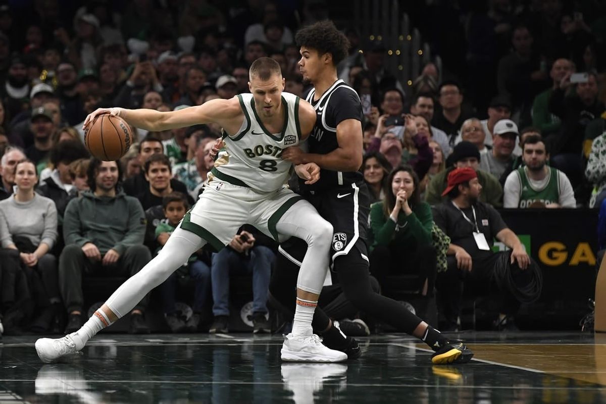 Nov 10, 2023; Boston, Massachusetts, USA;  Boston Celtics center Kristaps Porzingis (8) controls the ball while Brooklyn Nets forward Cameron Johnson (2) defends during the first half at TD Garden.