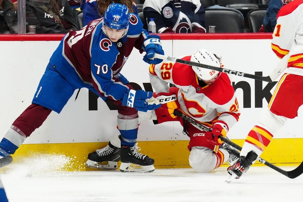 Dec 11, 2023; Denver, Colorado, USA; Colorado Avalanche defenseman Sam Malinski (70) hits Calgary Flames center Dillon Dube (29) in the third period at Ball Arena.