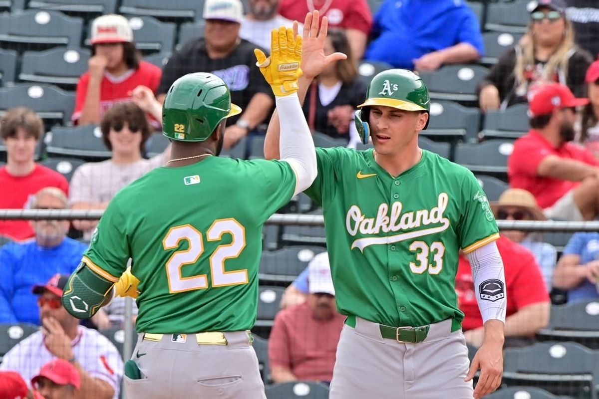 Mar 6, 2024; Tempe, Arizona, USA;  Oakland Athletics right fielder Miguel Andujar (22) celebrates with left fielder JJ Bleday (33) after hitting a three run home run in the first inning against the Los Angeles Angels during a spring training game at Tempe Diablo Stadium.