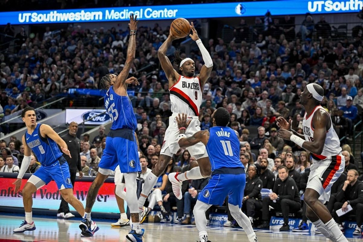 Jan 5, 2024; Dallas, Texas, USA; Portland Trail Blazers forward Jerami Grant (9) passes the ball over Dallas Mavericks forward Derrick Jones Jr. (55) and guard Kyrie Irving (11) during the second quarter at the American Airlines Center.