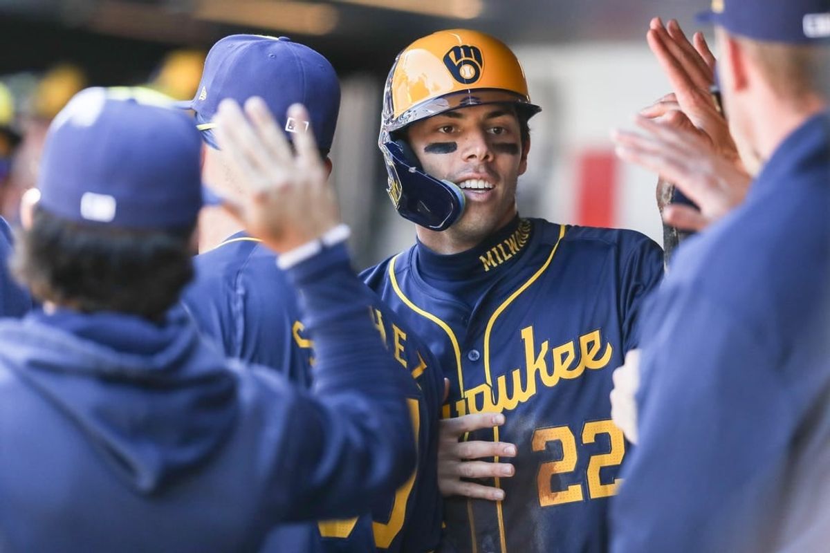 Mar 31, 2024; New York City, New York, USA;  Milwaukee Brewers left fielder Christian Yelich (22) is greeted in the dugout after scoring in the first inning against the New York Mets at Citi Field.