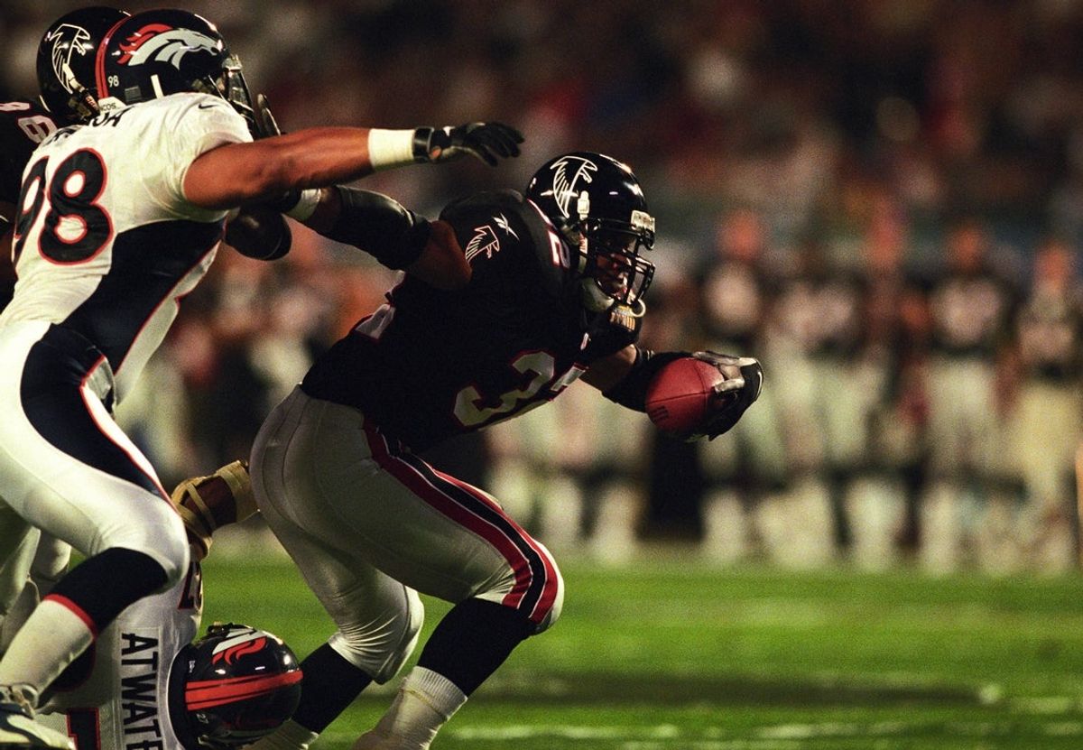 Jan 31, 1999; Miami, FL, USA; FILE PHOTO; Atlanta Falcons running back Jamal Anderson (32) carries the ball against Denver Broncos defenders Maa Tanuvasa (98) and Steve Atwater (27) during Super Bowl XXXIII at Dolphin Stadium. The Broncos defeated the Falcons 34-19. Mandatory Credit: RVR Photos-Imagn Images