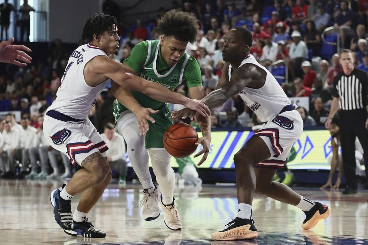 Jan 28, 2024; Boca Raton, Florida, USA; North Texas Mean Green guard CJ Noland (22) drives to the basket against Florida Atlantic Owls guard Bryan Greenlee (4) and guard Johnell Davis (1) during the first half at Eleanor R. Baldwin Arena.