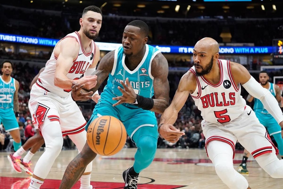 Jan 5, 2024; Chicago, Illinois, USA; Chicago Bulls guard Zach LaVine (8) and guard Jevon Carter (5) defend Charlotte Hornets guard Terry Rozier (3) during the first quarter at United Center.