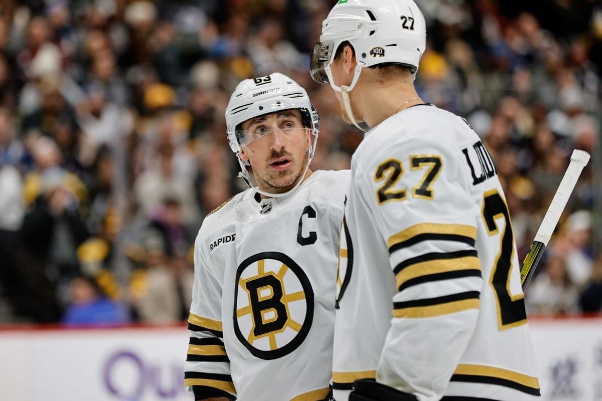 Jan 8, 2024; Denver, Colorado, USA; Boston Bruins left wing Brad Marchand (63) and defenseman Hampus Lindholm (27) in the second period against the Colorado Avalanche at Ball Arena.