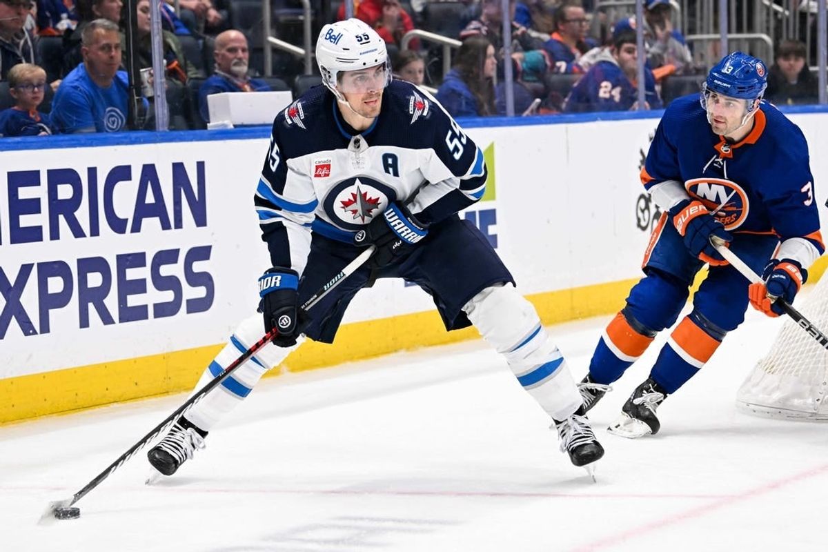 Mar 23, 2024; Elmont, New York, USA;  Winnipeg Jets center Mark Scheifele (55) skates with the puck chased by New York Islanders defenseman Adam Pelech (3) during the third period at UBS Arena.