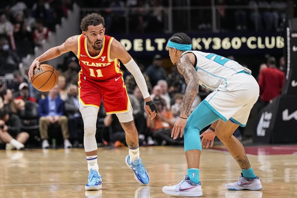 Apr 10, 2024; Atlanta, Georgia, USA; Atlanta Hawks guard Trae Young (11) dribbles against Charlotte Hornets guard Tre Mann (23) during the first half at State Farm Arena.