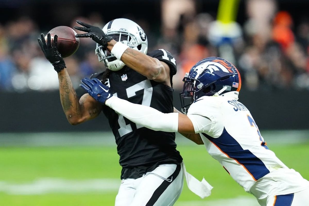 Jan 7, 2024; Paradise, Nevada, USA; Las Vegas Raiders wide receiver Davante Adams (17) makes a catch against Denver Broncos cornerback Pat Surtain II (2) during the second quarter at Allegiant Stadium.
