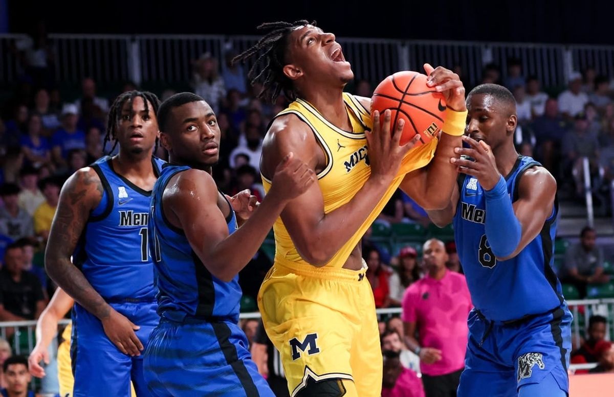 Nov 22, 2023; Paradise Island, BAHAMAS;  Michigan Wolverines forward Tarris Reed Jr. (32) controls the ball as Memphis Tigers guard Jayhlon Young (1) and Memphis Tigers forward David Jones (8) defend during the first half at Imperial Arena.